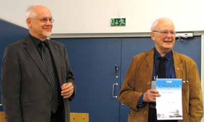 Kai R. Lehtonen (oik.) vastaanotti kunniakirjan MLY:n puheenjohtaja Raine Haikaraiselta.